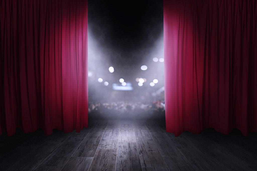 The red curtains of the stage are opening for the theater show