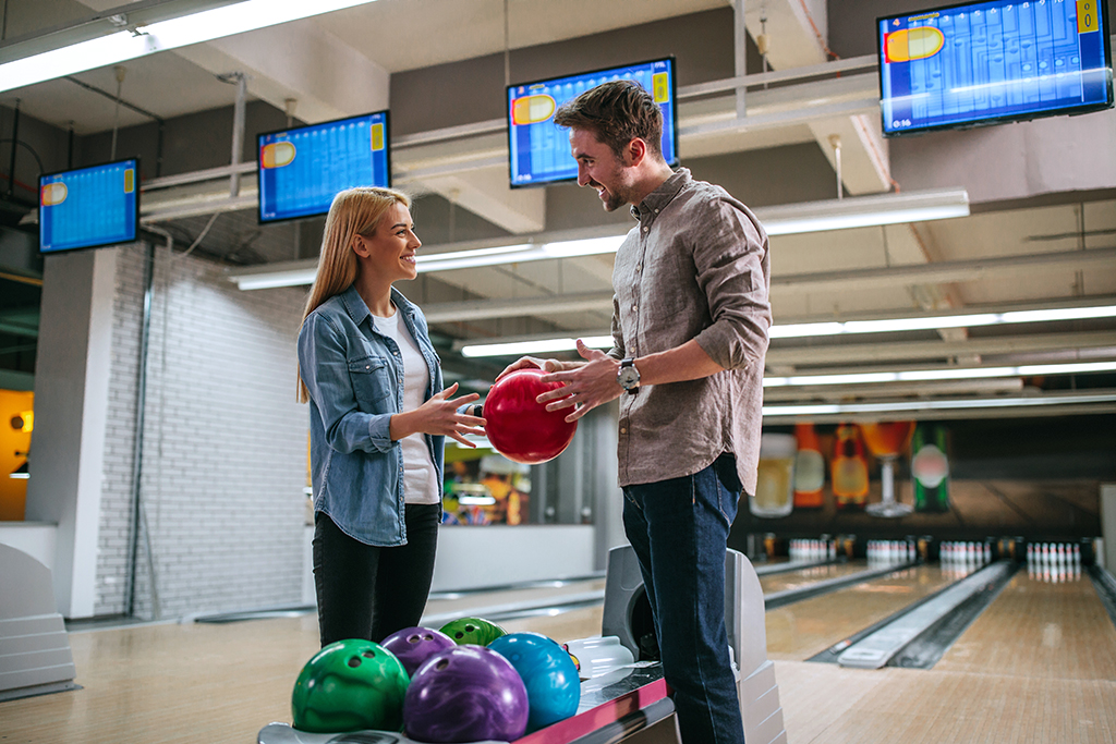 Shot of a young couple talking in the bowling club