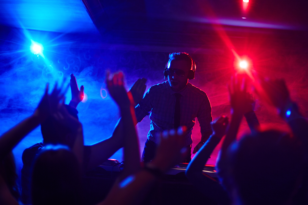 DJ firing up dancing crowd in night club