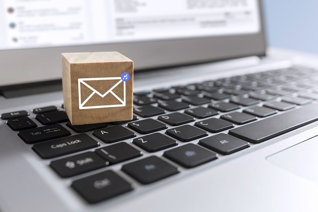 New email symbol on wooden block on laptop keyboard